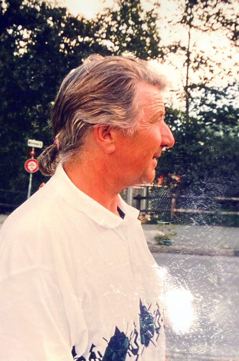 Sepp Bergamin im Profil mit zurückgebundenen langen Haaren, weisses Polo